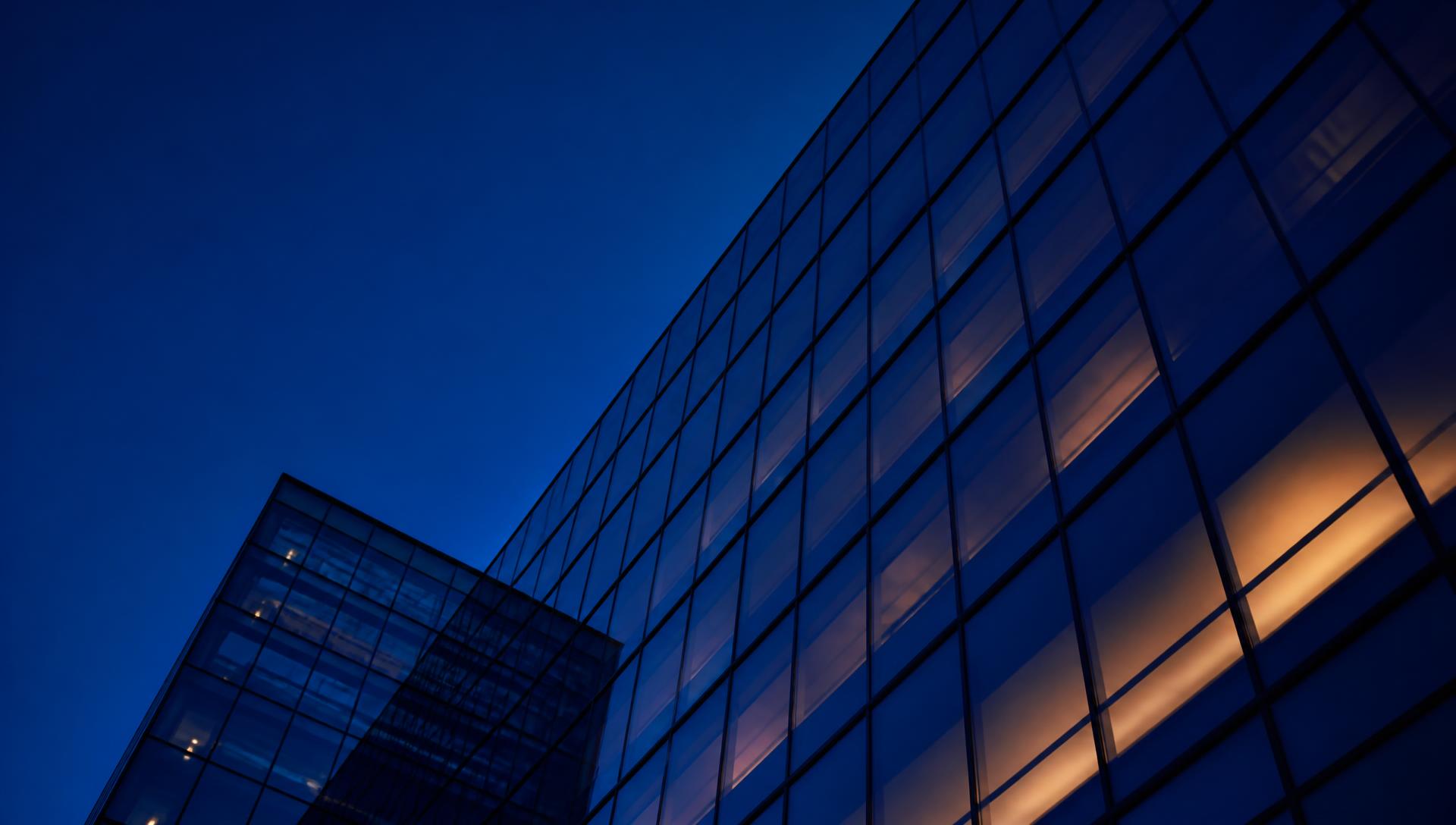 Modern glass office facade in Amsterdam at blue hour